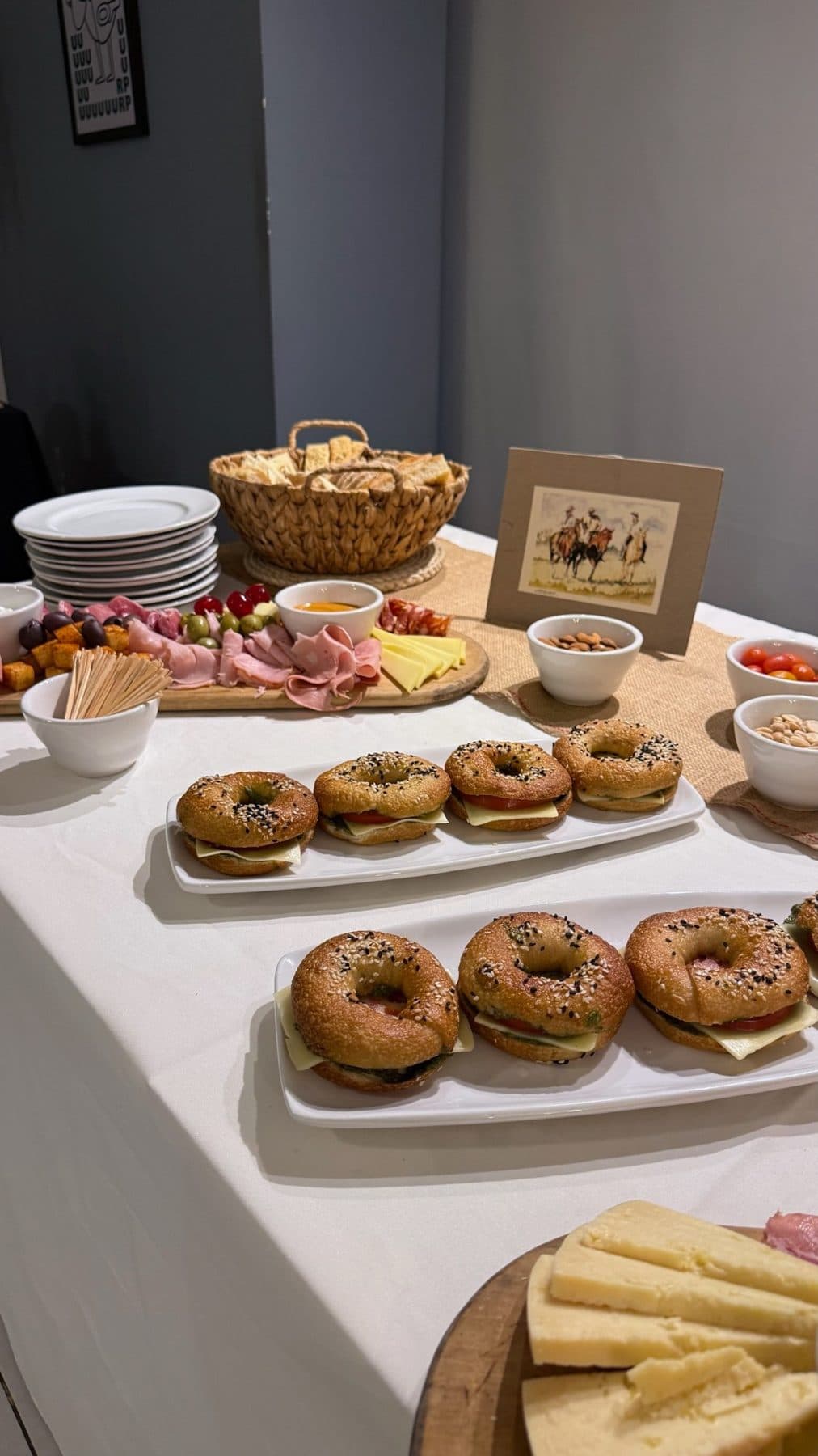 Mesa de lunch con bagels, tabla de fiambres y quesos