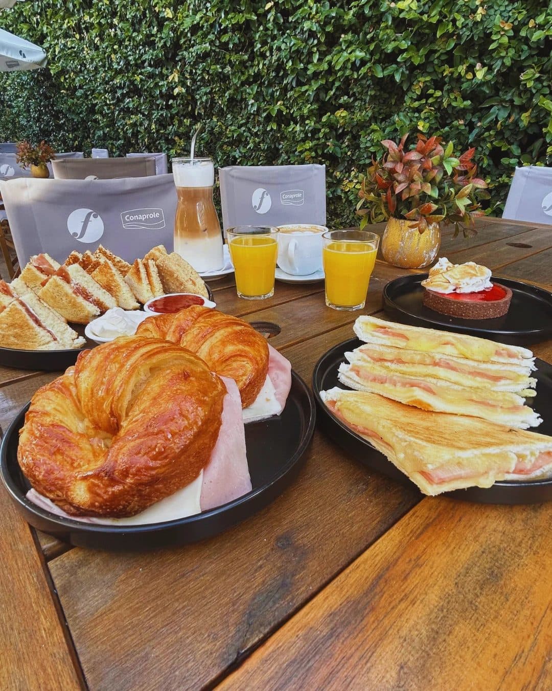 Mesa de la confitería con croissants, sándwiches tostados y jugos