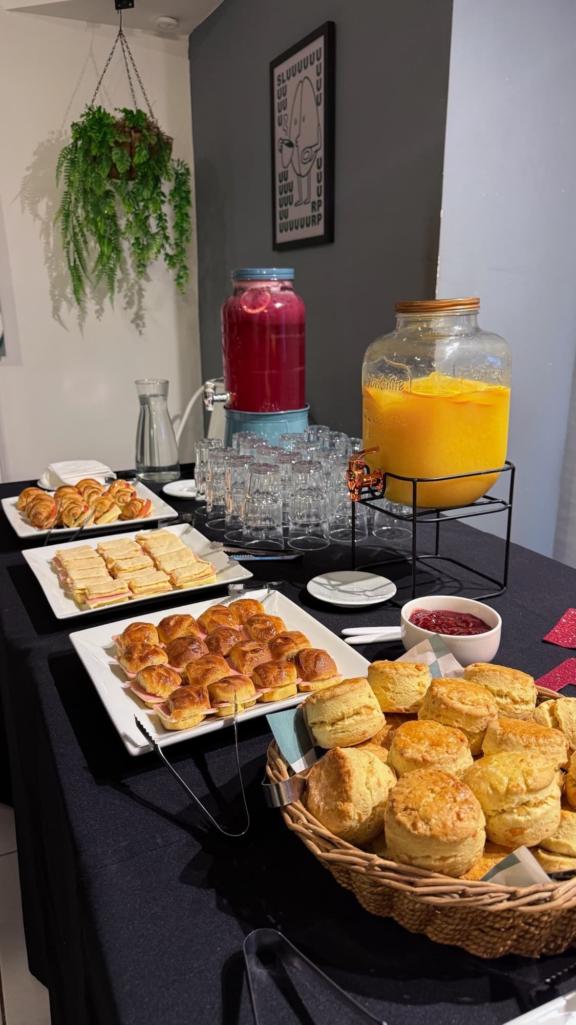 Mesa de lunch con scones, medialunas, sándwiches y jugos de elaboración propia
